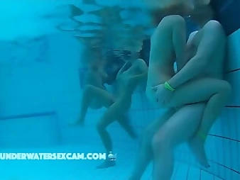 See these crazy nubile babes delight each other in a public pool, no shame!